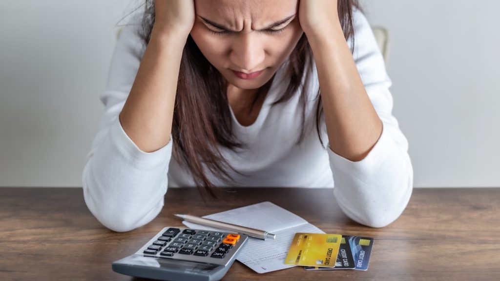 Stressed woman struggling with credit card debt and financial bills