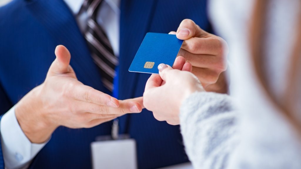 Banker handing new credit card to customer