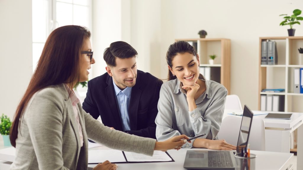 Financial advisor consulting young couple in office meeting