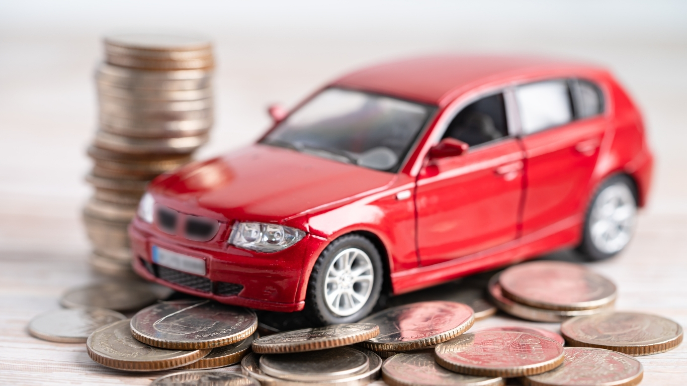 Car loan concept with red toy car and stacked coins