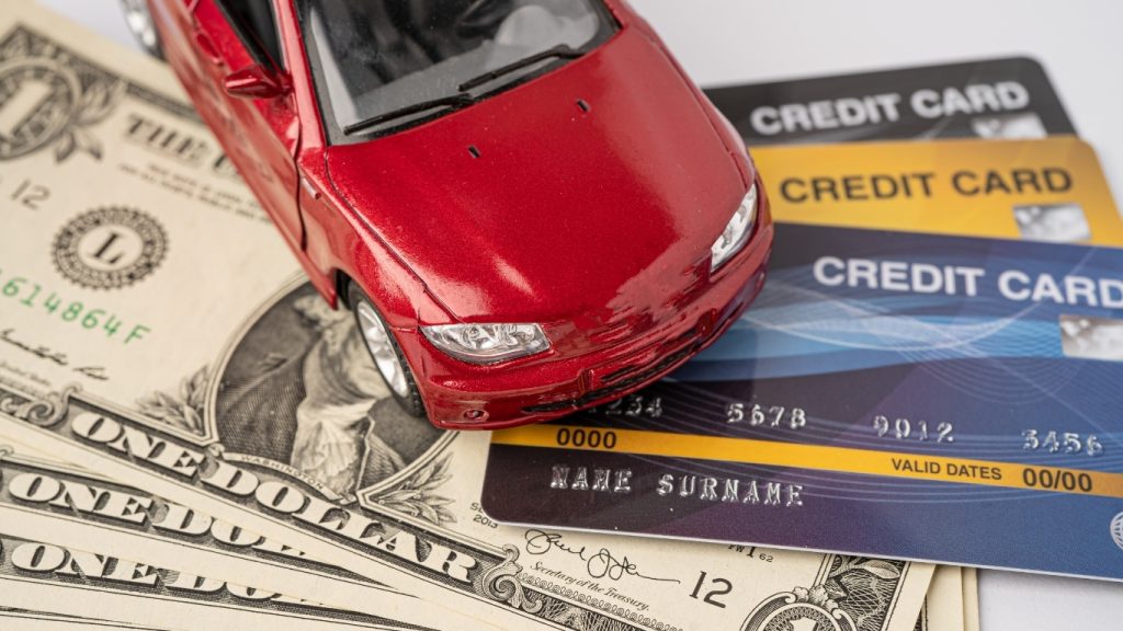 Car loan and credit concept with toy car, credit cards, and dollar bills