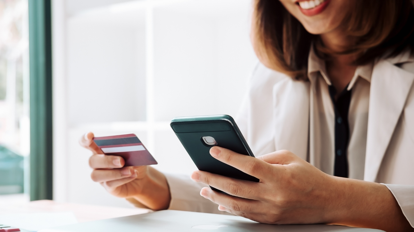 Woman making online payment using smartphone and credit card