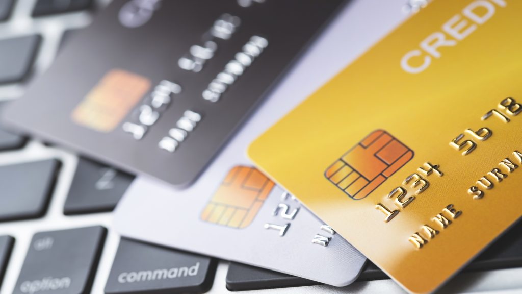 Credit cards on laptop keyboard – online payment and digital finance concept.