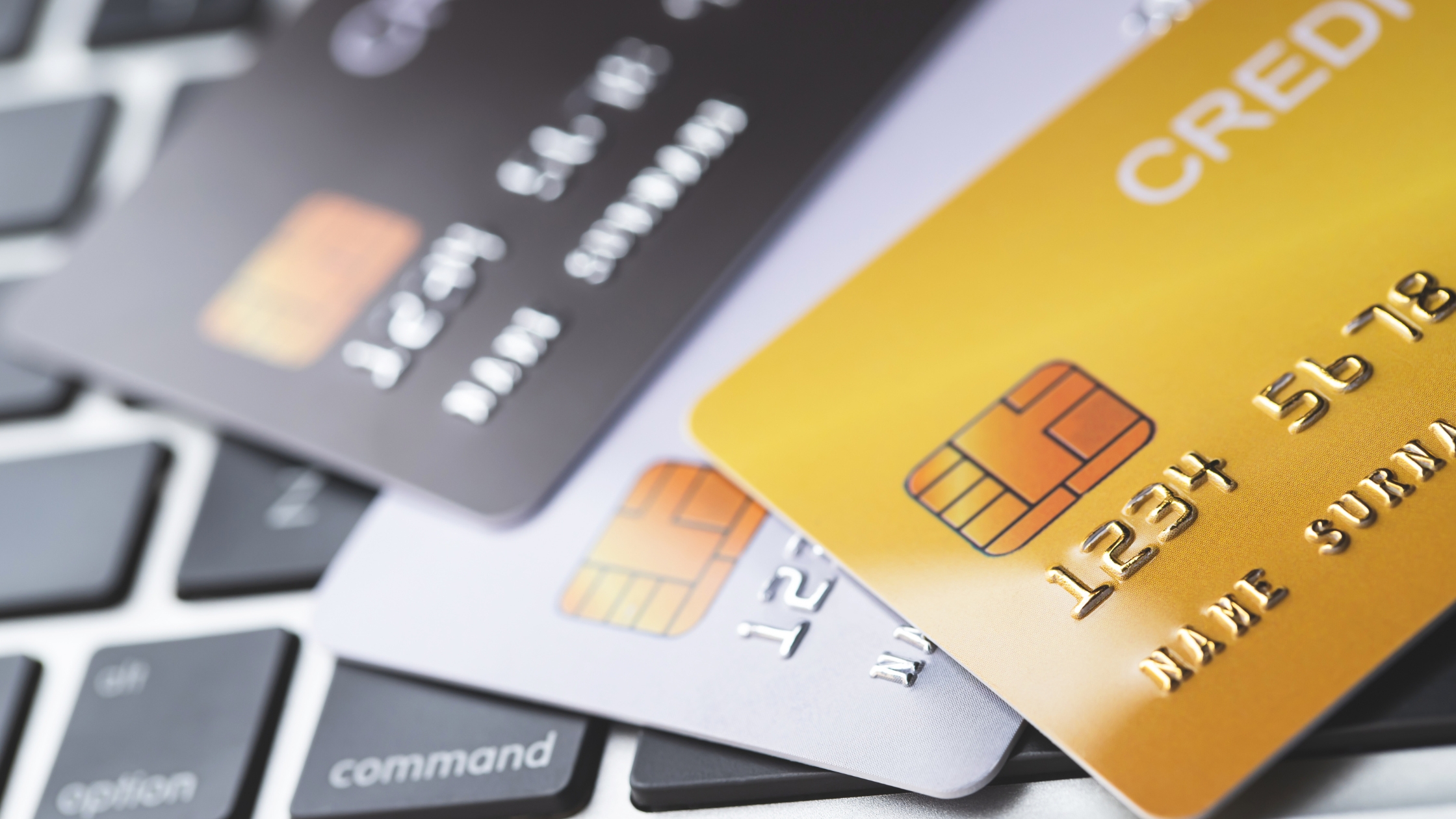 Credit cards on laptop keyboard – online payment and digital finance concept.