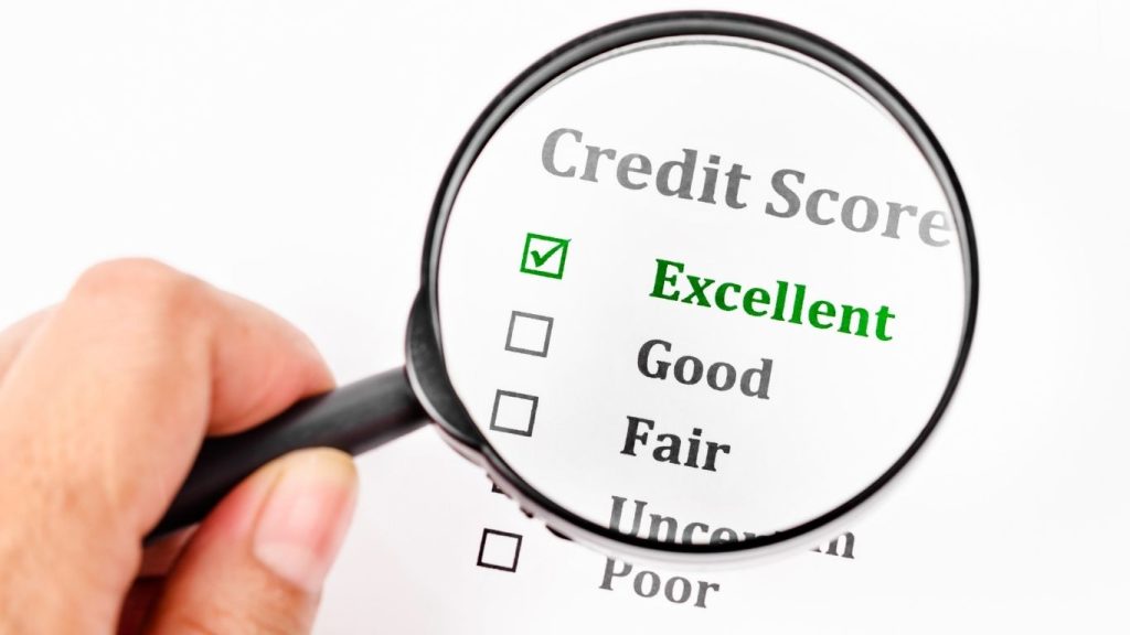 Magnifying glass highlighting 'Excellent' credit score on a checklist