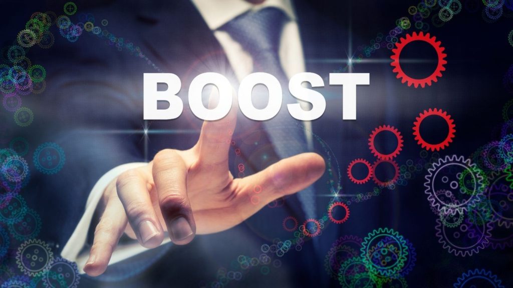 Businessman pointing to the word "BOOST" with gear icons, symbolizing business growth and credit improvement.