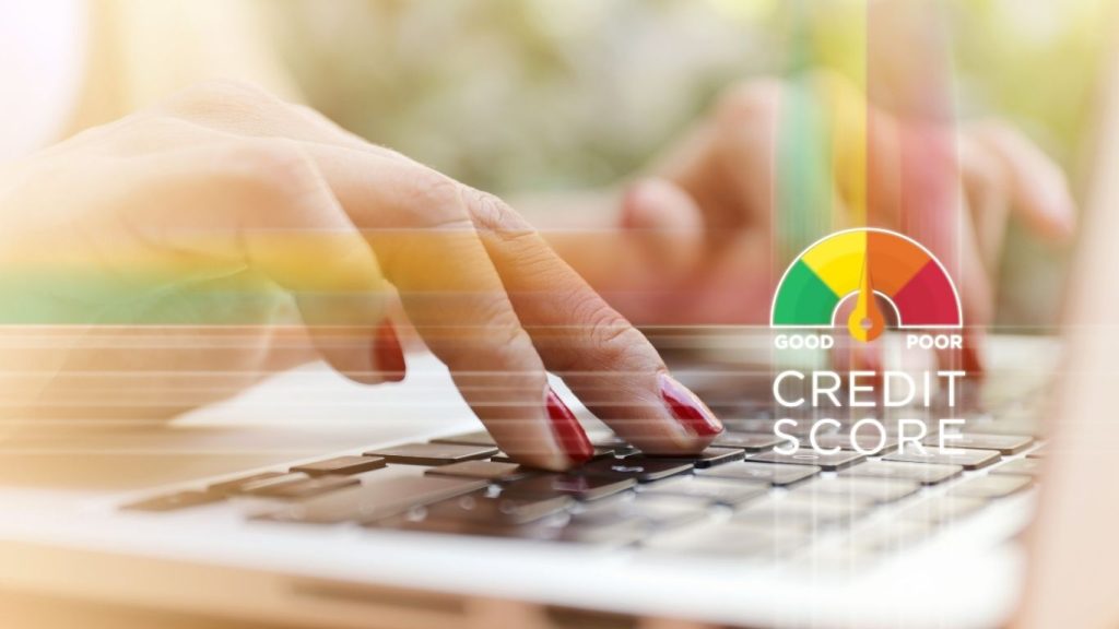 Close-up of hands typing on a laptop keyboard with a credit score meter overlay showing range from poor to good